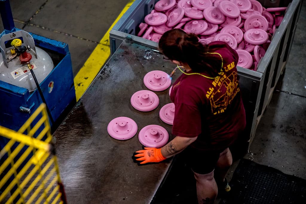 employee working on pink plastic parts